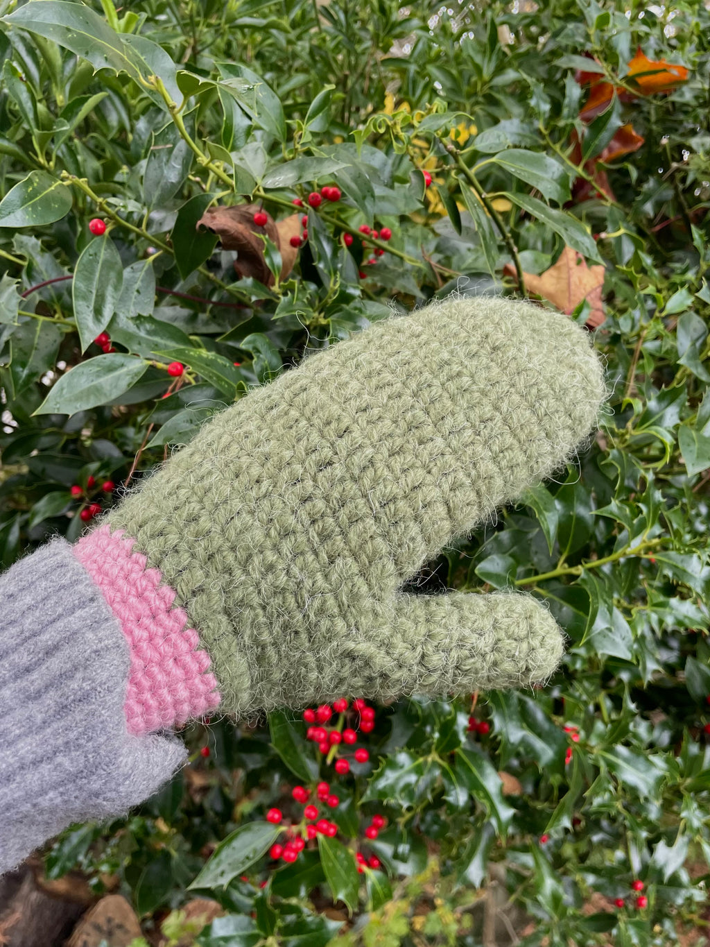 Green crochet mittens with pink edge